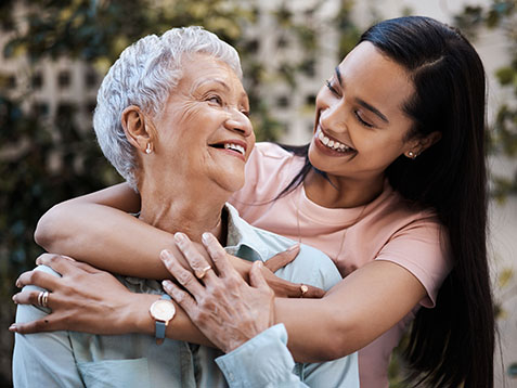 Happy, hug and loving of a mother and woman in a garden on mothers day with care and gratitude together. Smile, family and an adult daughter hugging a senior mom in a backyard or park for happiness.