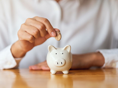 A woman putting coins into piggy bank for saving money concept