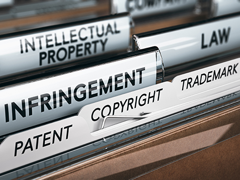 3D illustration of a folder, focus on a tab with the word infringement. Conceptual image of copyright law 