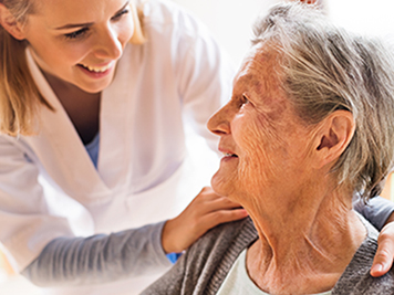 Health visitor and a senior woman during home visit. A nurse talking to an elderly woman.