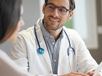  Modern young doctor speaking to patient in office                              