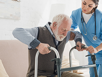 Doctor helping to retired man, getting up from sofa