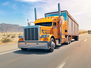 Yellow semi truck driving on a highway