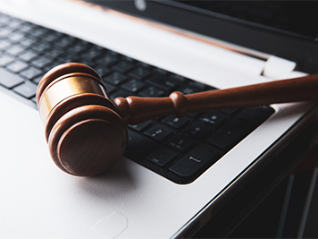 Brown gavel laying on a laptop keyboard