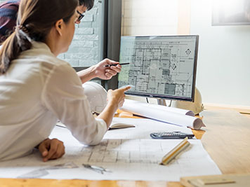 professional architect designer structural engineer team colleagues working office looking computer discussing building plan design project 