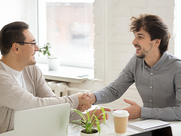 Workers greeting with handshake at company meeting