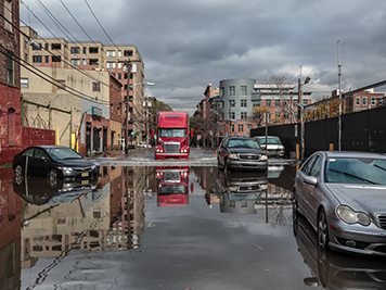 Truck driving down flooded street