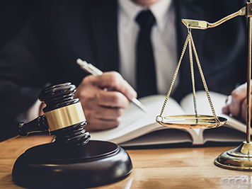 Professional Male lawyer or judge working with contract papers, documents and gavel and Scales of justice on table in courtroom, Law and Legal services concept