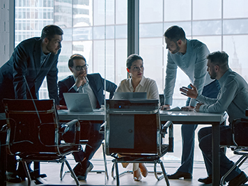 Group of business people working with technology at a meeting in a conference room in office