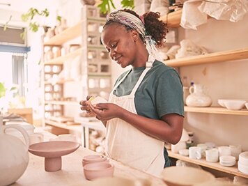 Woman creating with clay for her small business in creative workshop