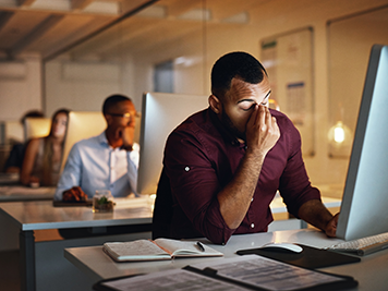 Business, night and man with stress, headache and burnout with new project, deadline and tired. Male person, employee and consultant with a migraine, pain and overworked and professional working late