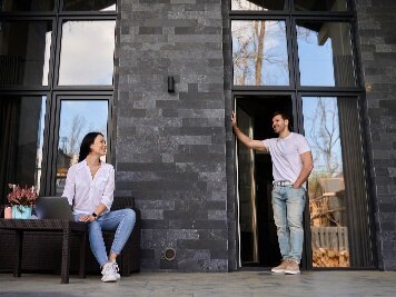 man and woman having conversation outside of building