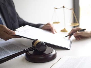 Professional having a person sign a legal document in a corporate setting