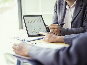 Business people analyzing investment charts with teblet in meeting room, Accounting concept, soft focus, vintage tone