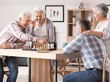 Elderly people playing chess in nursing home