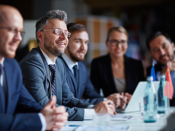 Successful businesspeople sitting at conference or seminar during lecture