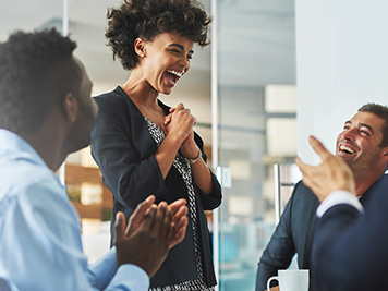 Shot of colleagues laughing together in an office