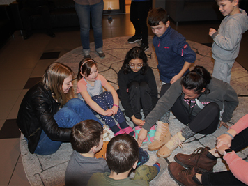 Supervisors sitting on the floor in a circle with kids