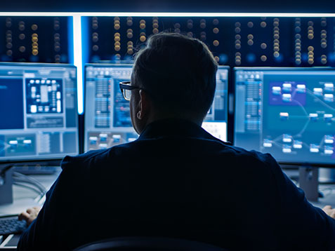 Professional IT Programer Working in Data Center on Desktop Computer with Three Displays, Doing Development of Software and Hardware. Displays Show Blockchain, Data Network Architecture Concept